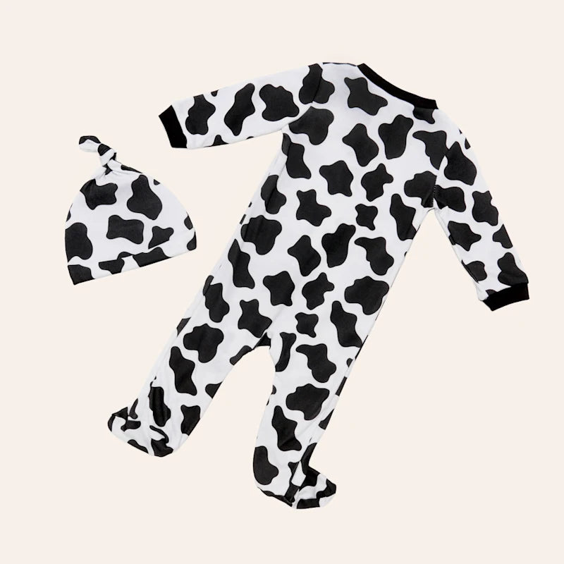Black and white Cowprint onesie for a baby with a matching stocking cap